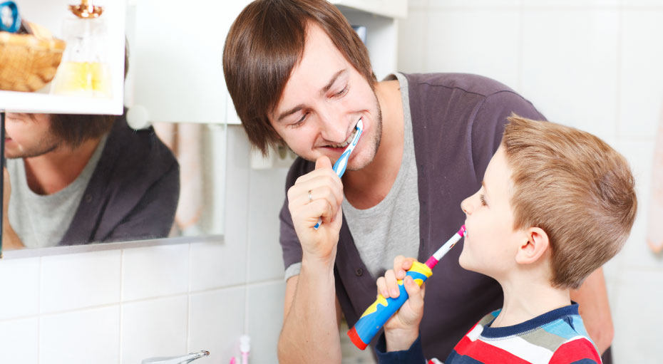 Leading by example helps kids develop the habit of brushing their teeth.