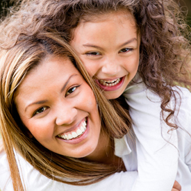 smiling child piggybacking on her mom 2